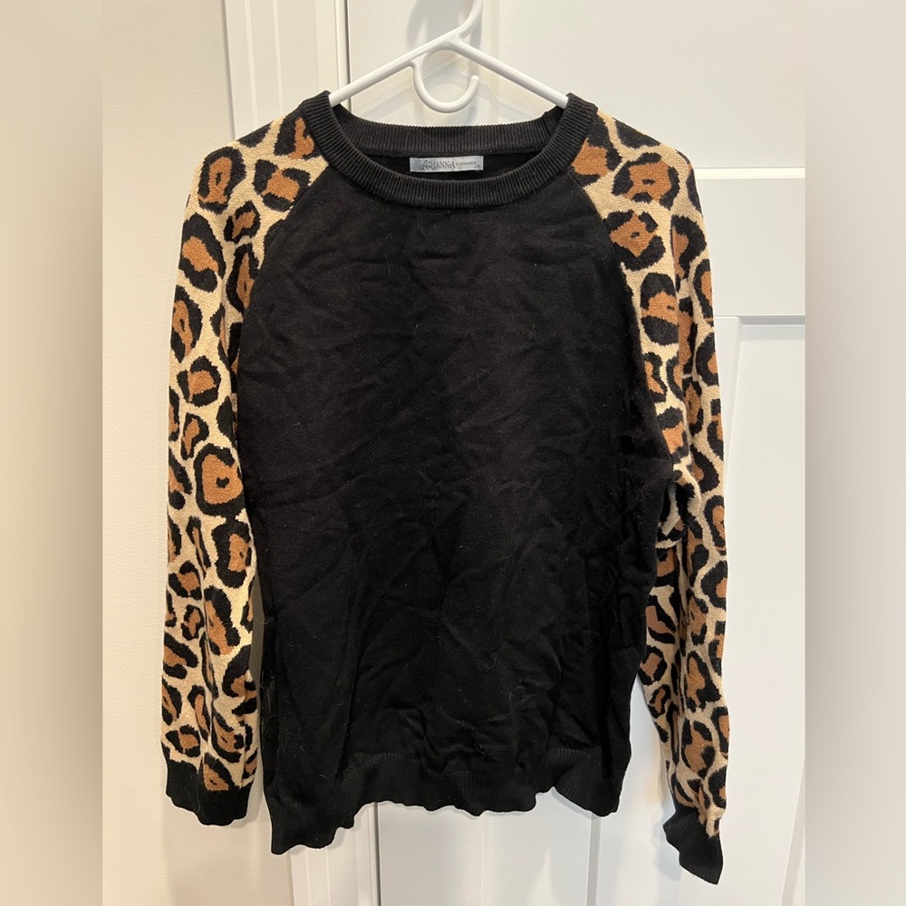 Black sweater with leopard print sleeves.
